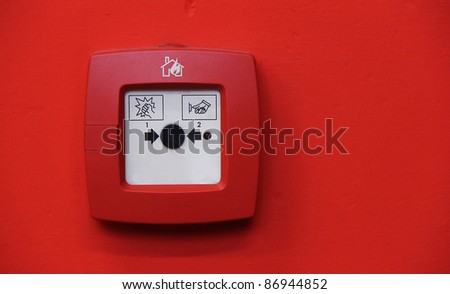 fire alarm system button on red wall