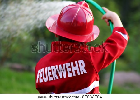 little fire man in the garden with the water hose