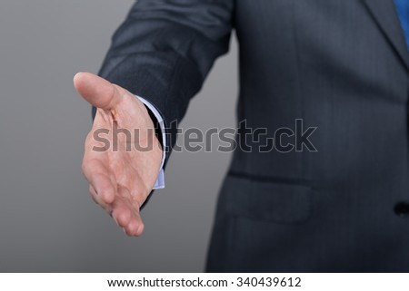 Businessman offering his hand for handshake. Greeting or congratulating gesture. Business meeting and success