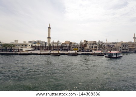 DUBAI CREEK, UAE - MARCH 24 - Skyline view of Dubai Creek with traditional boat taxi activity. The creek is dividing the city into two main sections Deira and Bur Dubai. Picture taken on March 24,2013