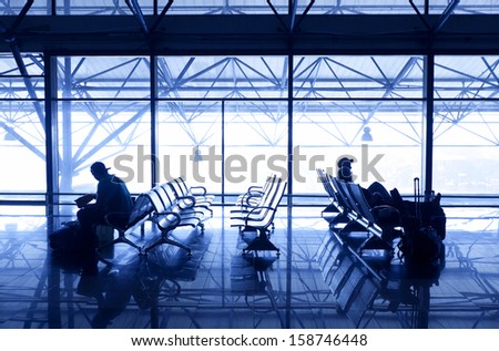 Silhouettes Of People Traveling On Airport; Waiting At The Plane Boarding Gates.
