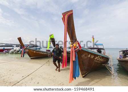 KRABI, THAILAND - JULY 7 : Unidentified boat driver and longtail boat ride on the shuttle service tourists to the islands on July 7,2013 in Krabi ,Thailand.