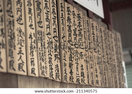 TOKYO, JAPAN - MAY 27 : Wooden prayer tablets at a shrine on May 27,2014. In Japan they pray for happiness, good life, health, peace and luck by writing prayers on a wooden tablet.