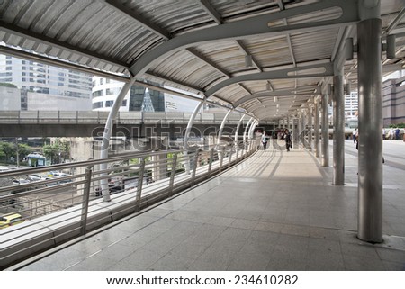 SATHORN ROAD, BANGKOK - NOV 21, 2014: High-Rise buildings and a sky walk at Sathorn-Narathiwas intersection in Bangkok,Thailand. Sky walk is the connecting walkway between sky train and rapid bus.