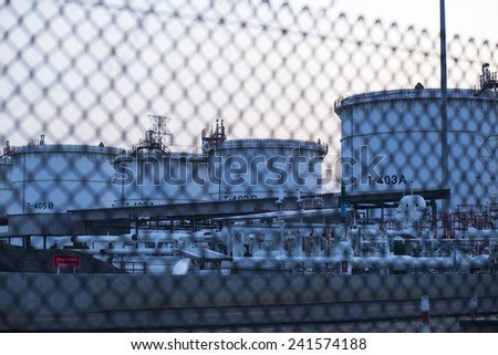 Wire fence of oil tank refinery,focus at the fence.