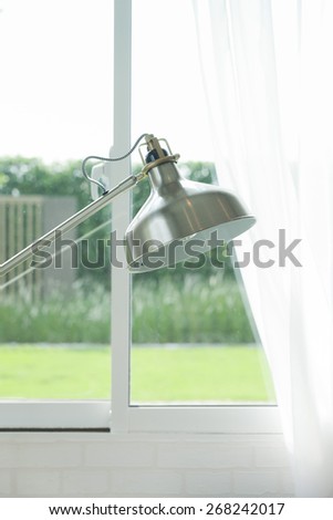 Metal floor lamp standing by the window