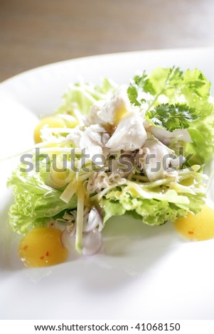 thai spicy crab salad with slices mango, fusion food
