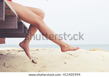 Woman\'s legs at beach jetty