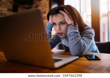Frustrated worried young woman looks at laptop upset by bad news, teenager feels shocked afraid reading negative bullying message, stressed girl troubled with problem online or email notification.