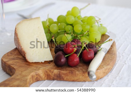 Cheese platter with tom goat cheese and fruits. Cheeseboard
