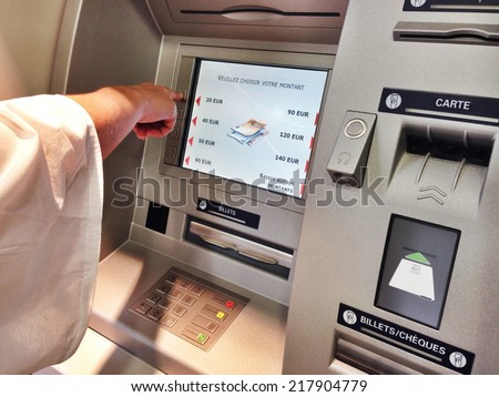 A person takes money at an ATM bank