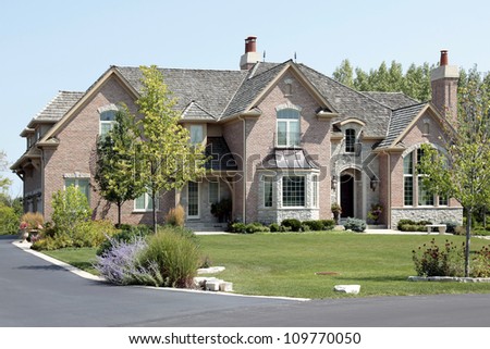 Large suburban brick and stone home with arched entry