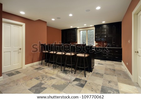 Bar in basement of luxury home with dark wood cabinetry