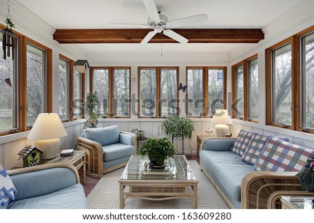 Sunroom With Wood Ceiling Beam And Wicker Furniture