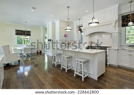 Large kitchen in luxury home with white cabinetry