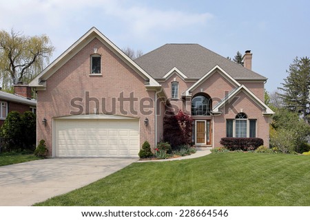 Suburban brick home with arched window above entry