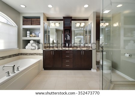 Master bath in luxury home with dark wood cabinetry