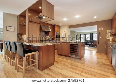 Kitchen with wood cabinets and bar chairs
