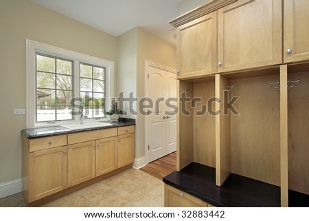 Mud room in new construction home with oak cabinetry
