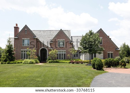 Brick home in suburbs with cedar shake roof