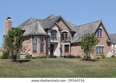 Large brick suburban home with front balcony