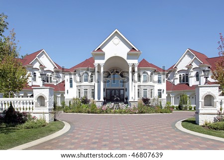Large luxury home with arched entry and tiled roof