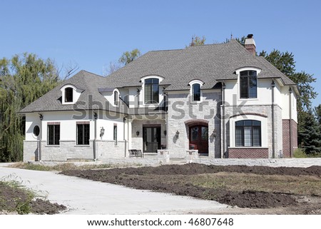 New construction home in suburbs with unfinished landscaping