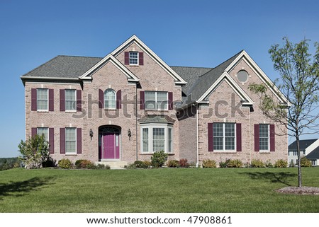 Brick home in suburbs with pink door