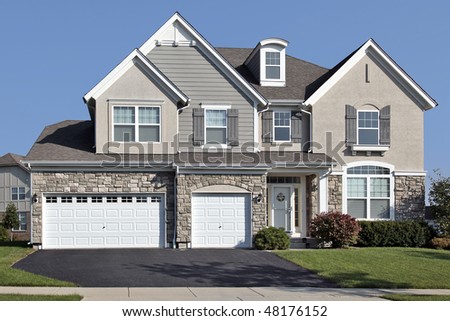 Home in suburbs with three car stone garage