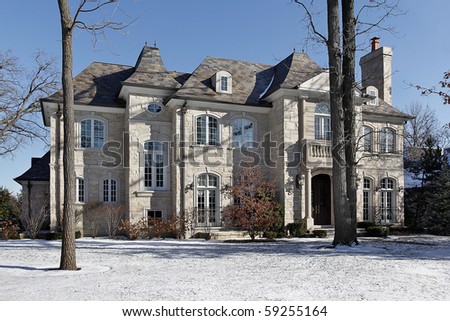 Luxury stone home in winter with front balcony