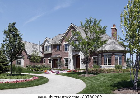 Large brick home in suburbs with stone entry