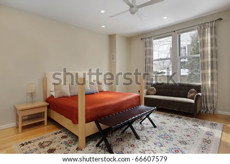Guest bedroom in luxury home with orange bedspread