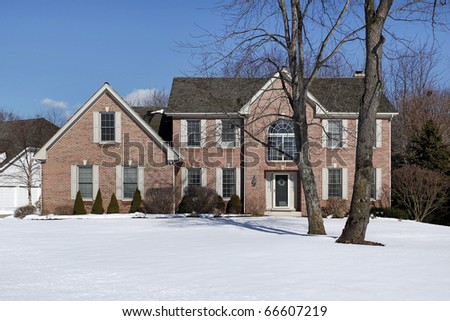 Large brick home in suburbs in winter