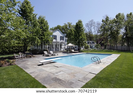Swimming pool outside luxury home with diving board