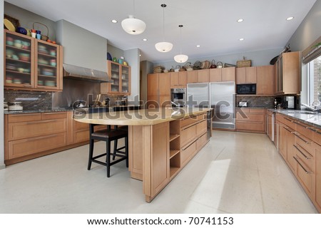 Large kitchen in luxury home with oak wood cabinetry