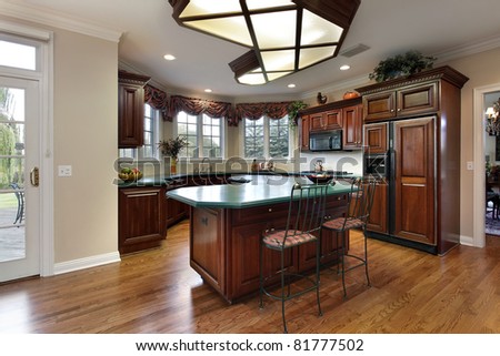 Kitchen with dark wood cabinets and green island counter