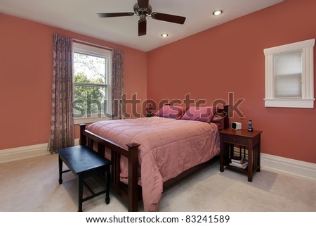 Master bedroom with peach colored walls and ceiling fan