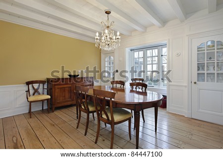 Dining room with white ceiling wood beams and gold walls