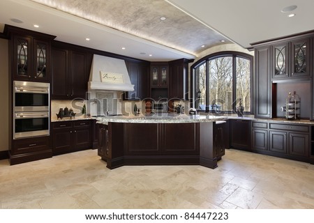 Large kitchen in luxury home with dark wood cabinetry