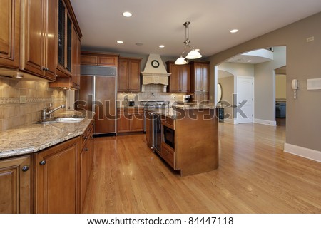 Kitchen in remodeled home with wood cabinetry