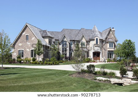 Large luxury brick home with stone turret