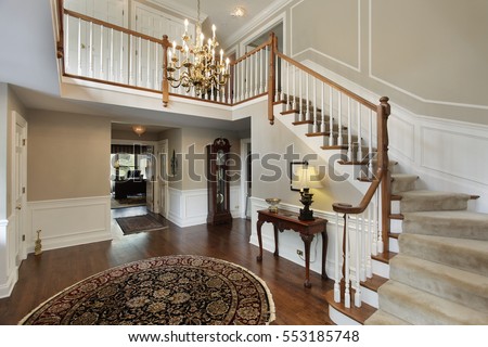 Foyer in luxury home with carpeted stairs.