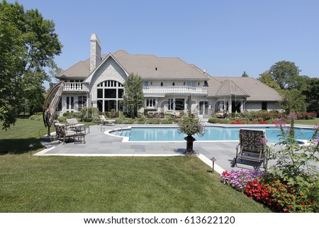 Swimming pool in back of luxury home with blue stone deck.