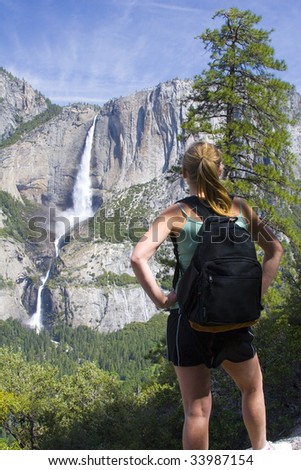 Young woman  looking at Yosemite Falls in the Sierra Nevada mountains of California