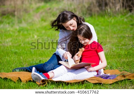 Mom and daughter reading a book on nature
