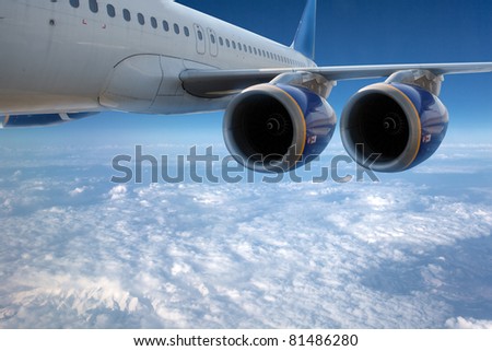 Big airliner in the blue sky with clouds.