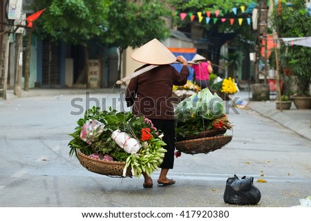 Women selling flowers in the early morning in a small market, Hanoi, Vietnam. Life of florist vendor in Hanoi, Vietnam.