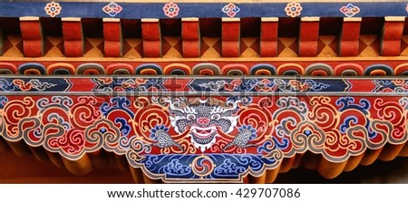 Colorful Bhutanese art of Tibetan dragon painted on wood at the entrance of house at Paro, Bhutan