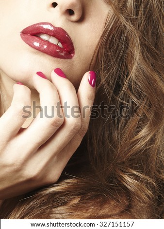 women close up with red and glossy lips and fuchsia nail polish
