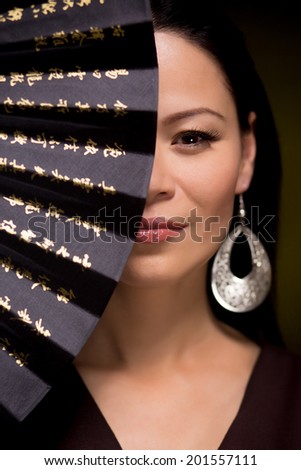 Beauty portrait of asian woman with hand fan on dark background